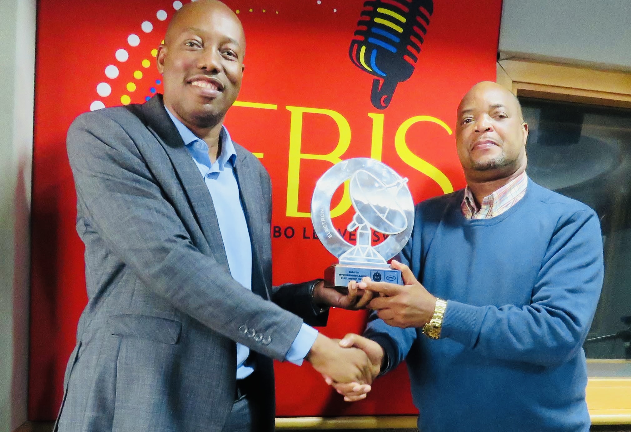 State owned radio gets Best Electronic Media Award at MTN Eswatini Premier League Awards, Presenter Moses ‘Mthetho’ Matsebula hands it over to his boss Director Sibusiso Dlamini.