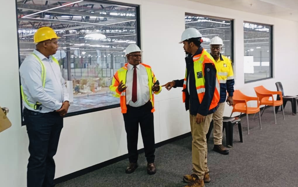 Prince Mcwasho joins Commerce Minister Mancoba Khumalo in touring under construction Jonnson Workwear factory.